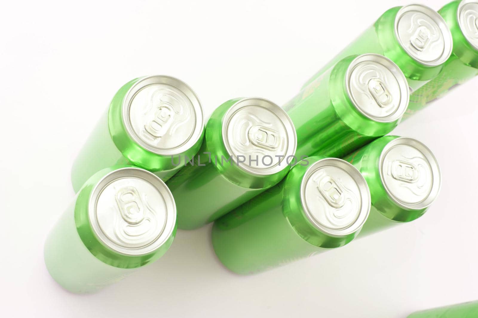 Group of green unopened aluminium soda or soft drink cans viewed from above on a white background