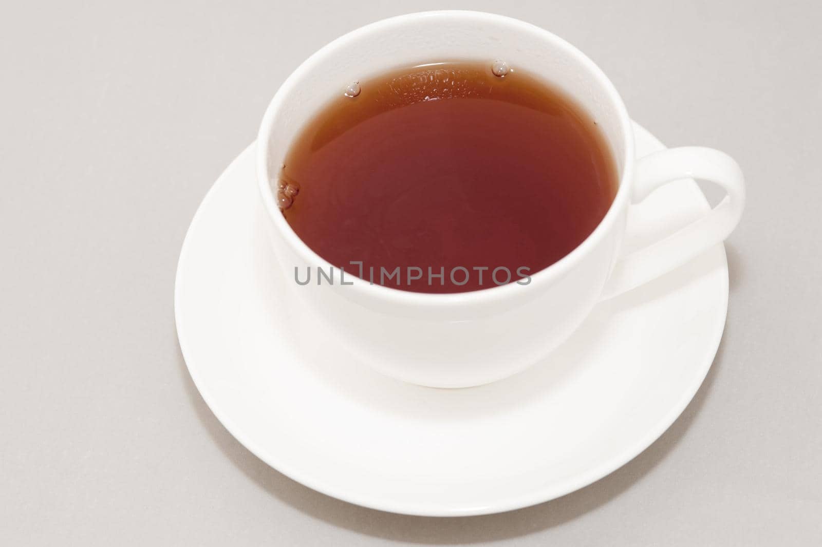 High Angle View of Hot Brewed Black Tea in Clean White Cup on Saucer in Studio with Neutral Gray Background