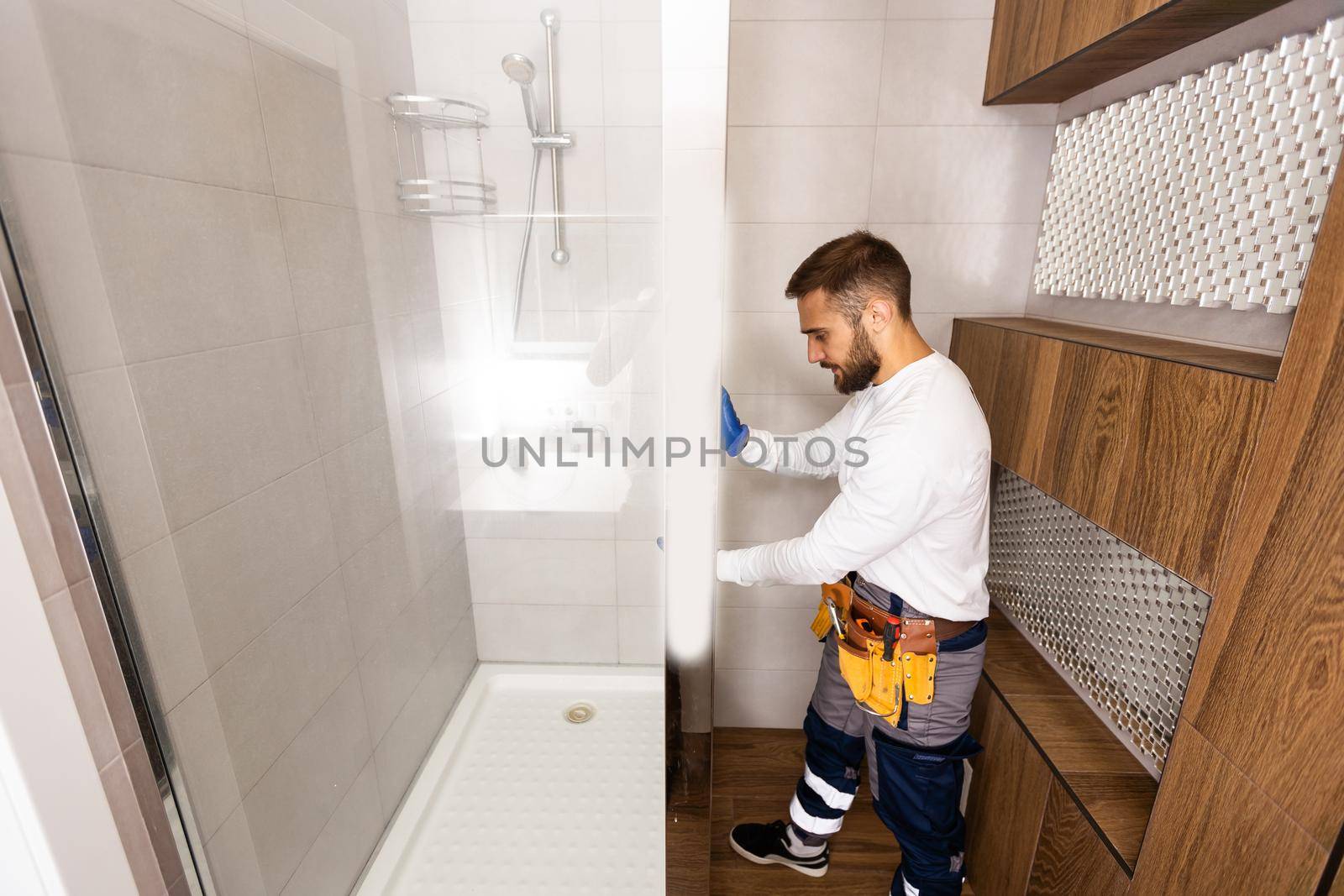Professional plumber with plunger and instruments near sink
