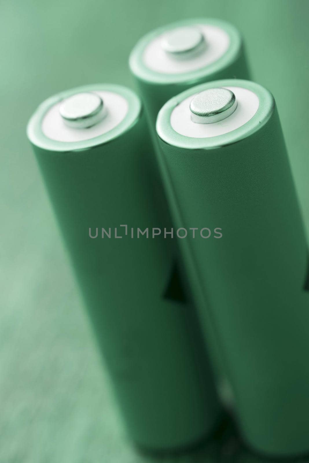 Three standing green batteries on plain background by sanisra