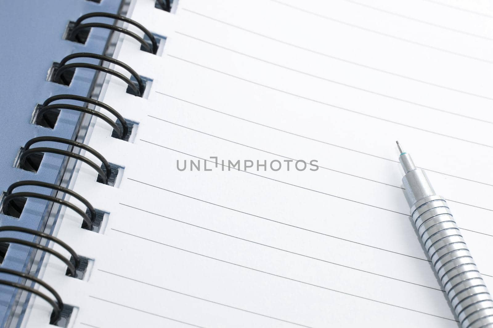 Open ringbound notebook with blank lined pages and a mechanical pencil ready for you to write your text or message