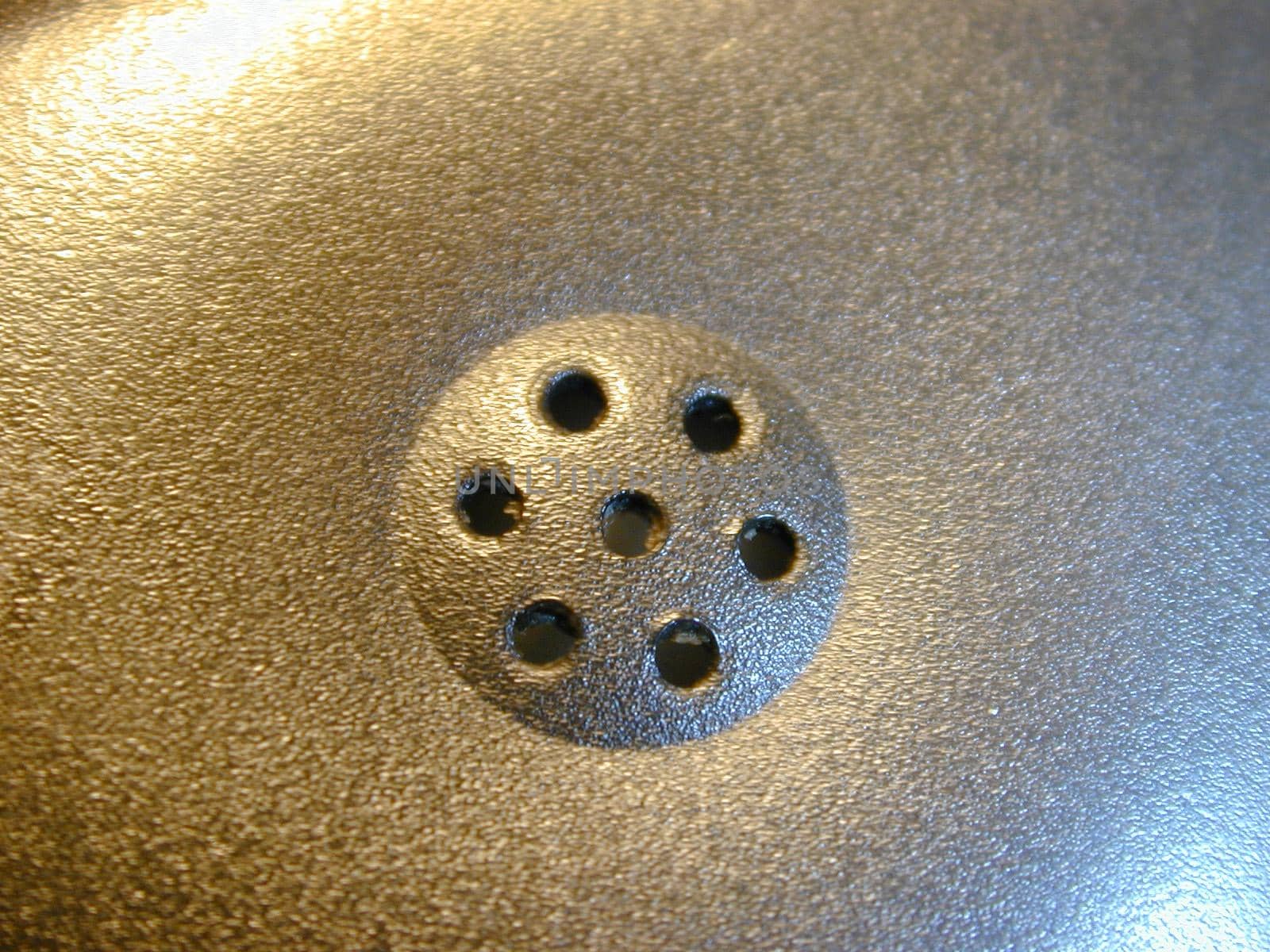 Macro close up on telephone earpiece section speaker with seven little holes in the middle