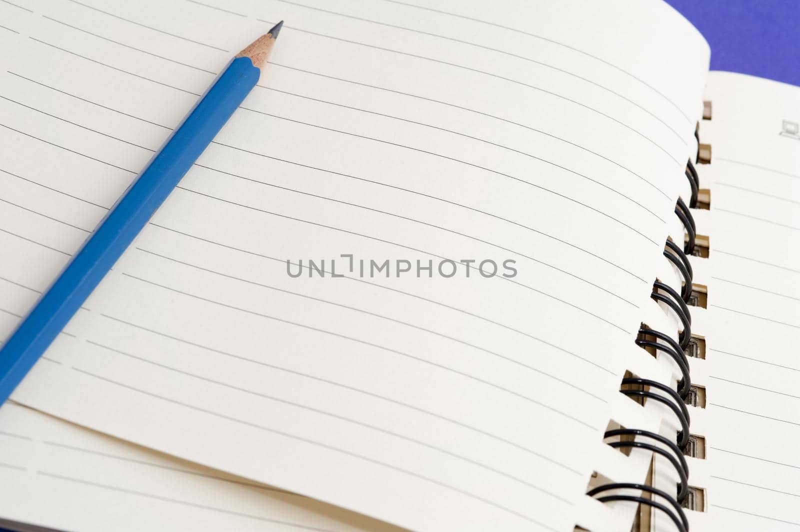 Pencil lying on a blank notebook ready for your note or message to be written