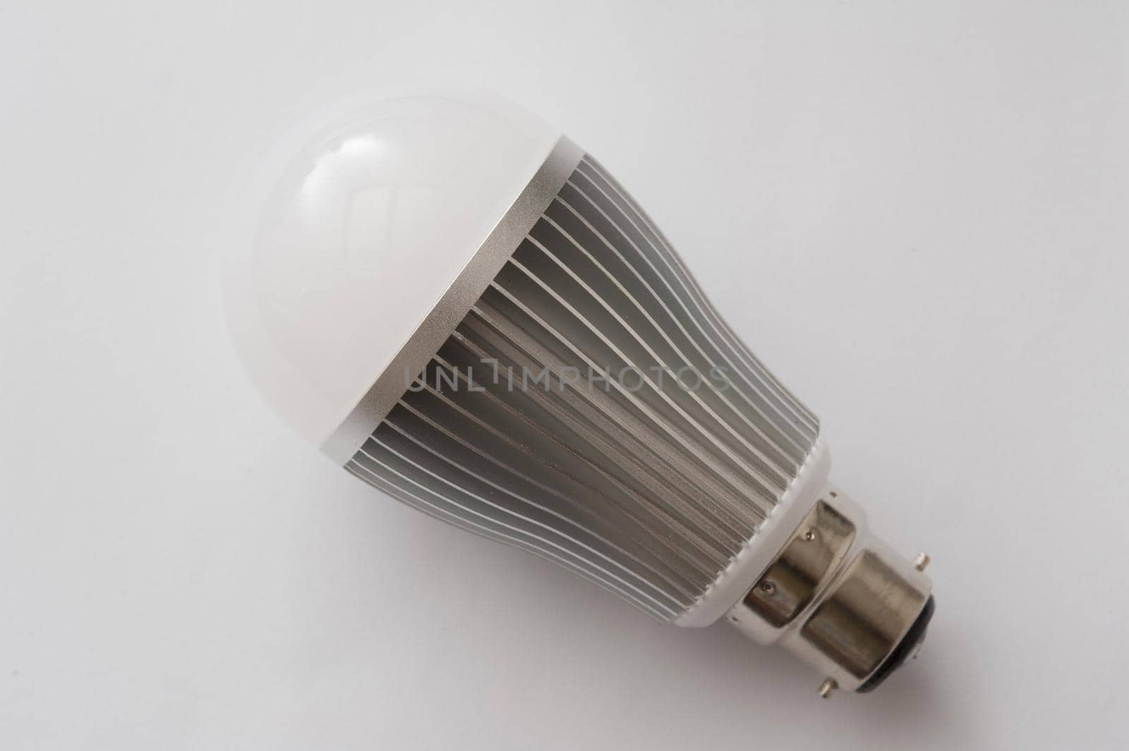 Energy efficient LED lamp with B22 base close-up on white surface background