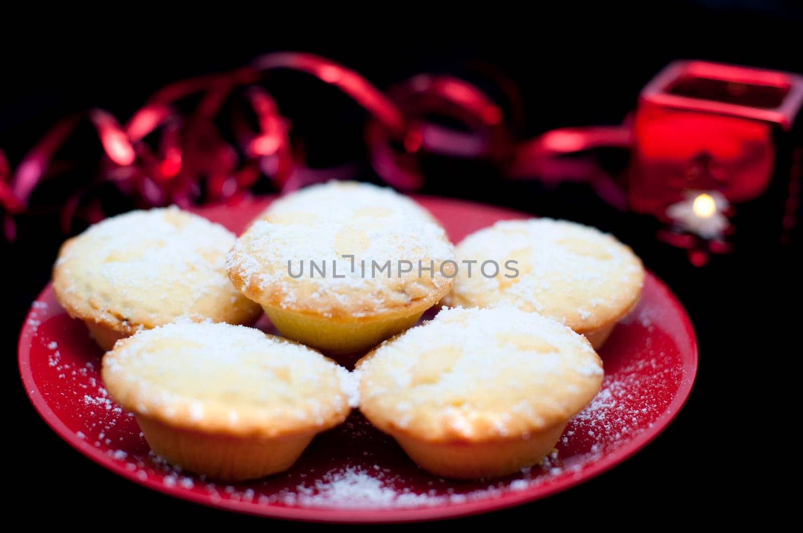 Plate of five golden freshly baked Christmas mince pies with a rich fruit filling sprinkled with sugar for a festive seasonal treat