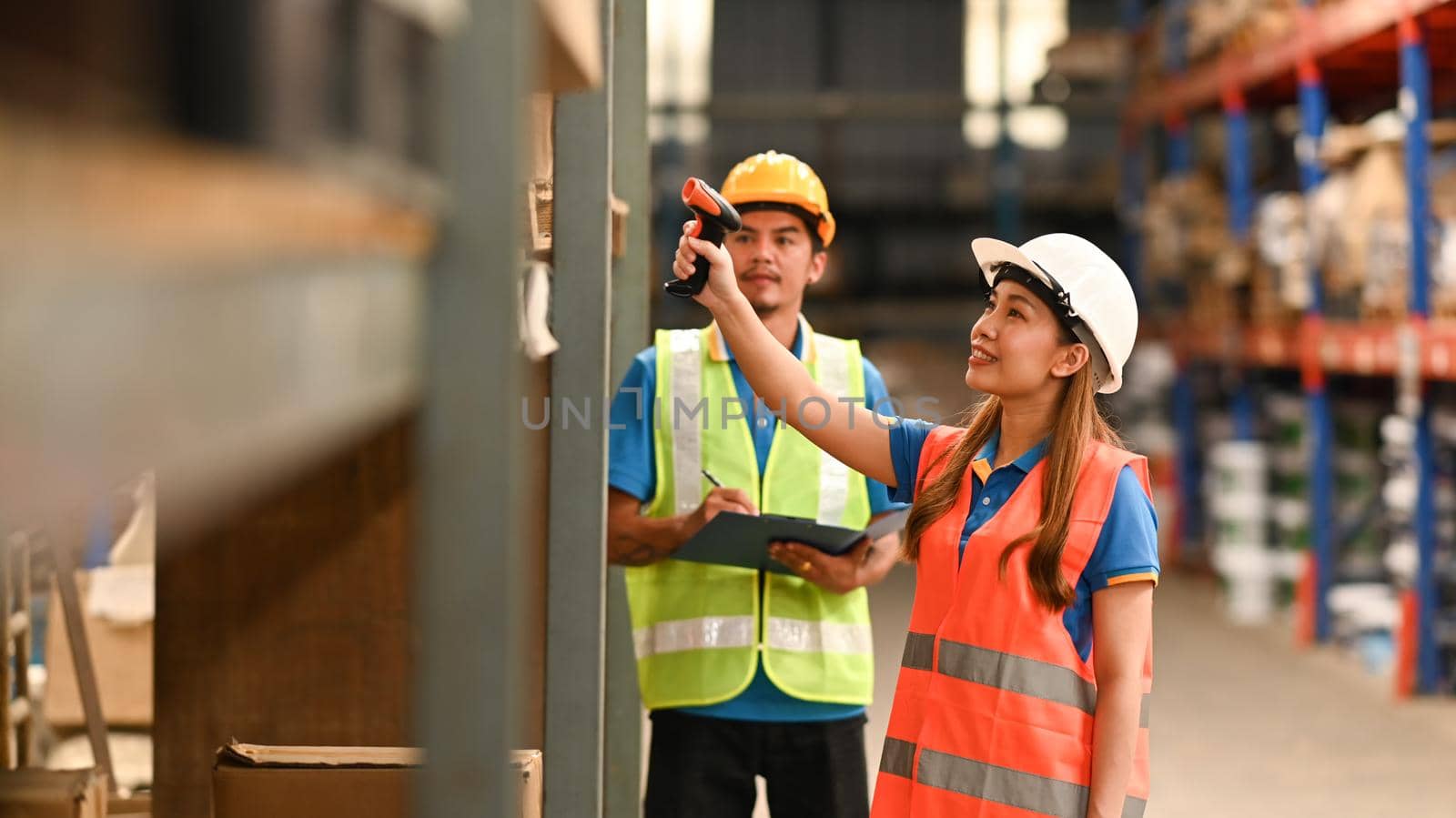 Storehouse employees workers in hardhats and and vests working together in warehouse. Logistics, and manufacture storehouse occupation concept.