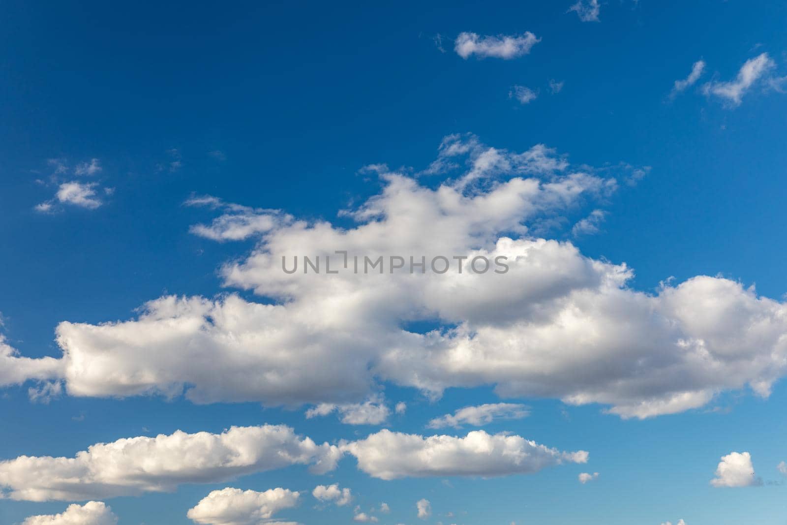 Sunny sky abstract background, beautiful cloudscape, on the heaven, view over white fluffy clouds, freedom concept. Aerial view of sky and white clouds. View from airplane. 