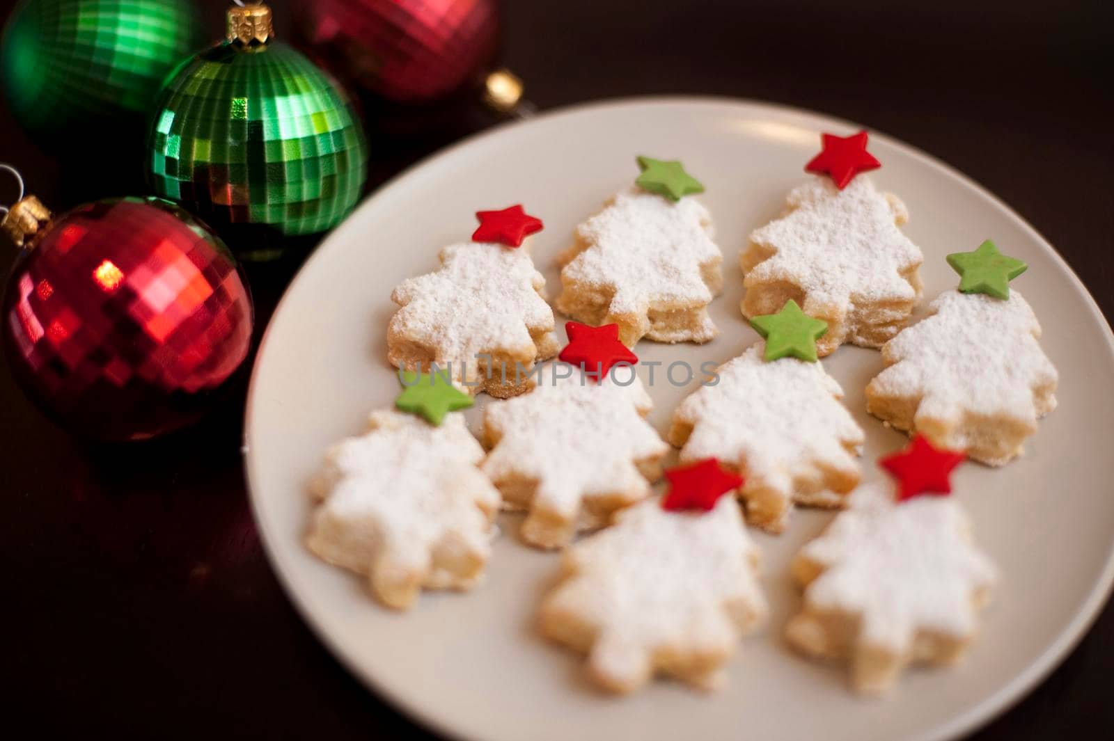 Tasty golden Christmas cookies in the shape of Christmas trees home baked to celebrate the festive Xmas holiday