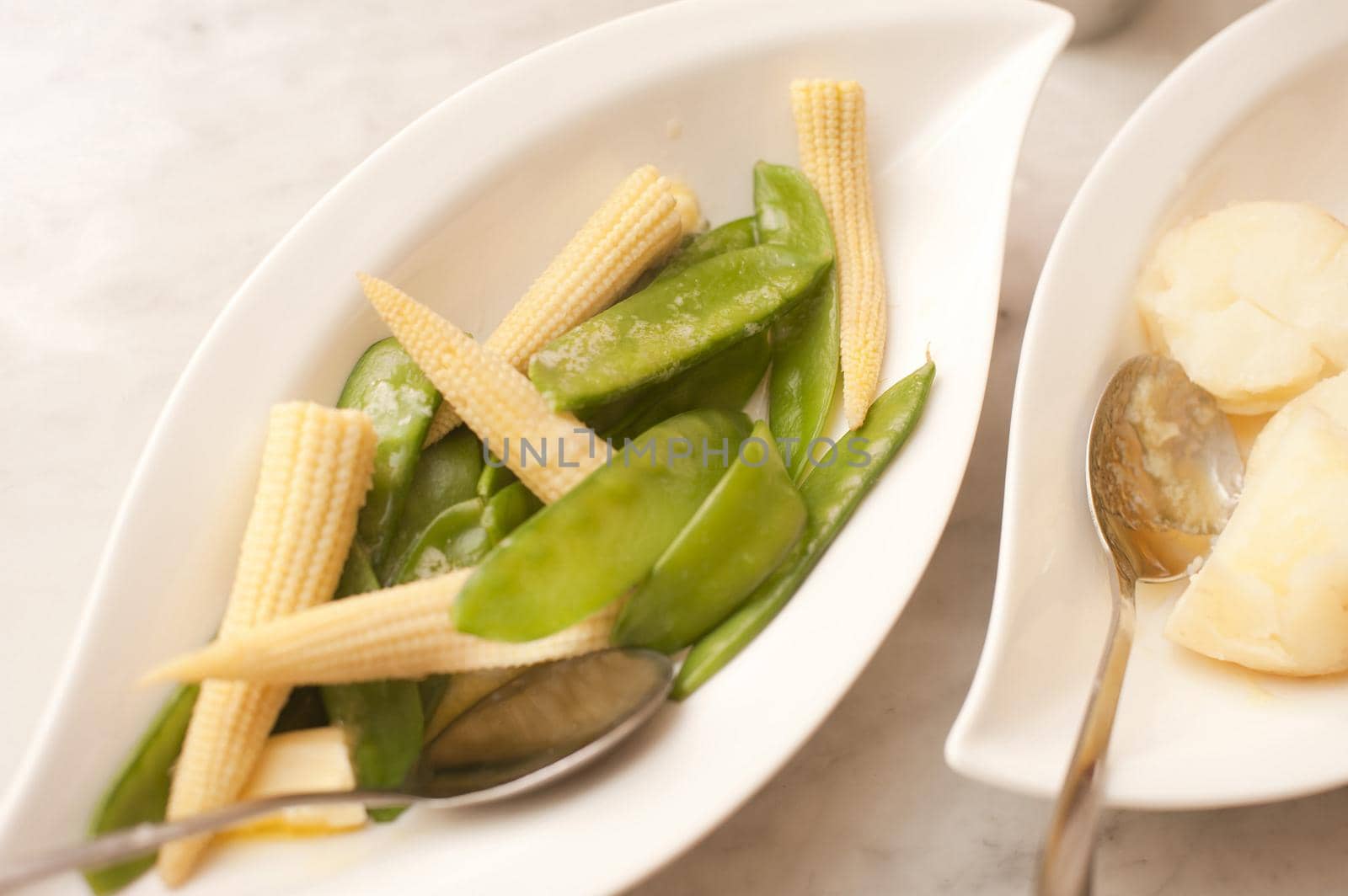 Vegetable side plate with mangetout peas and miniature corn on the cob for a tasty healthy acoompaniment to a meal