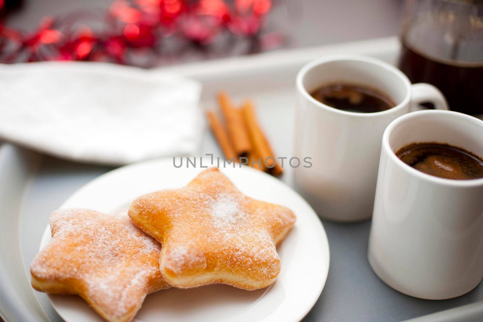 Christmas coffee break with festive star-shaped sugared doughnuts served with mugs of freshly brewed espresso coffee