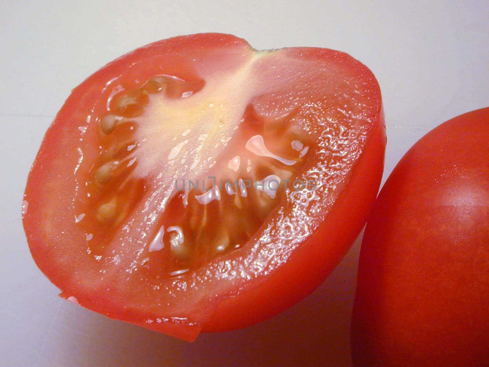 Halved ripe fresh juicy tomato showing the pips and pulp for a delicious healthy cooking or salad ingredient rich in antioxidants and vitamins