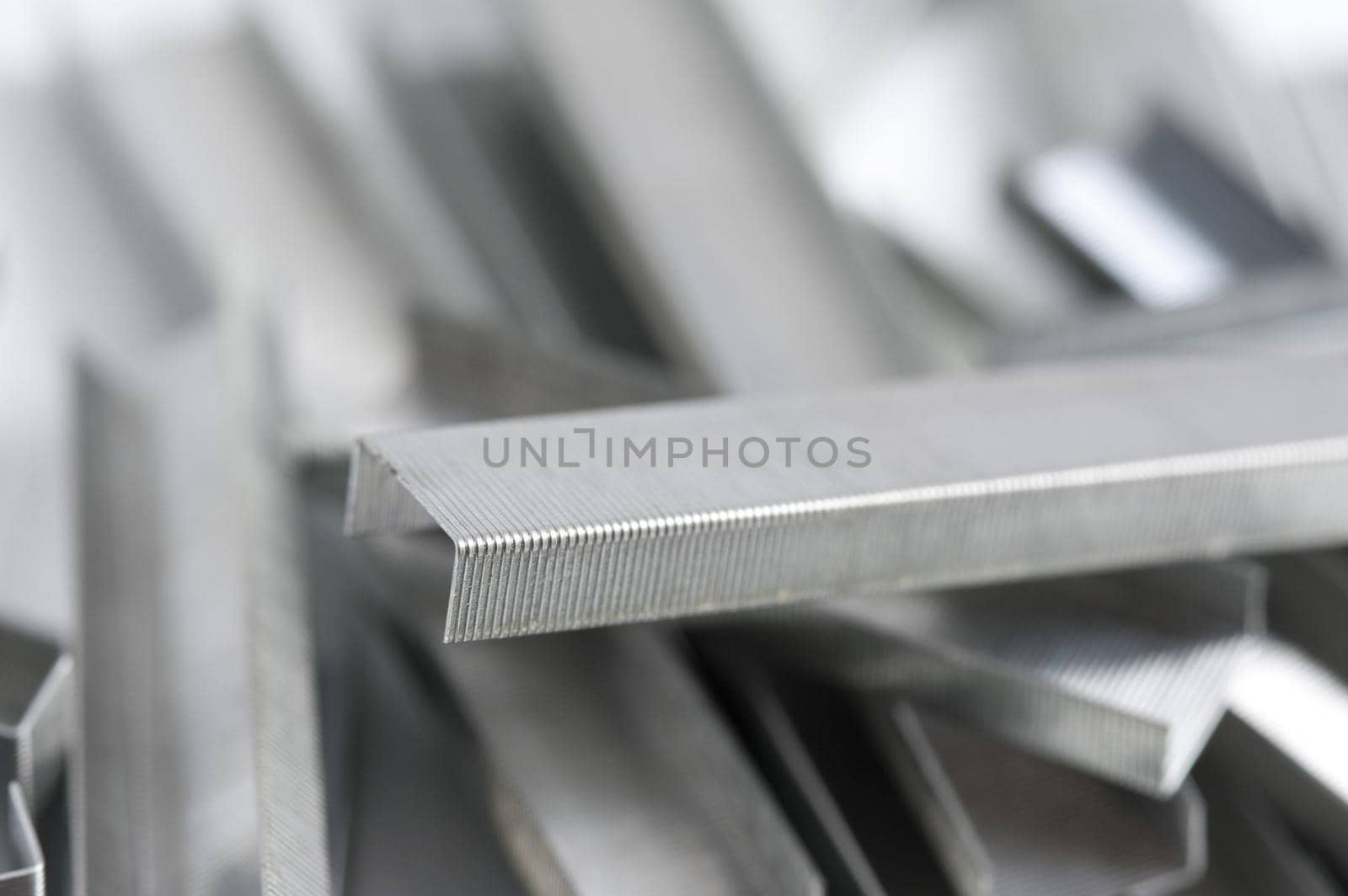 Jumbled messy wire staple background with focus to the end of one block of joined staples
