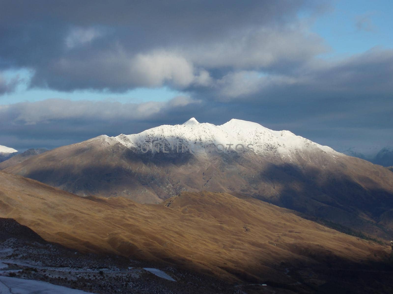 a snow covered new zealand mountain, as viewed from coronet peak