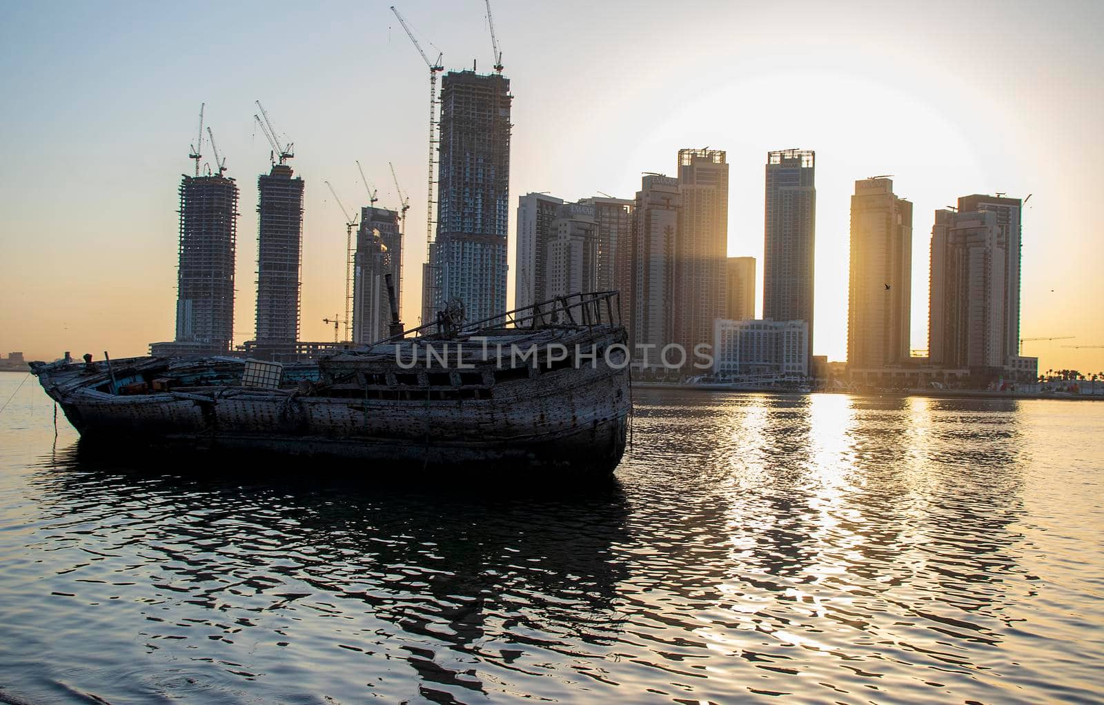 Sunrise in Jadaf area of Dubai, view of Dubai creek Harbor construction of which is partially completed. Old abandoned ships can be seen on the scene by pazemin