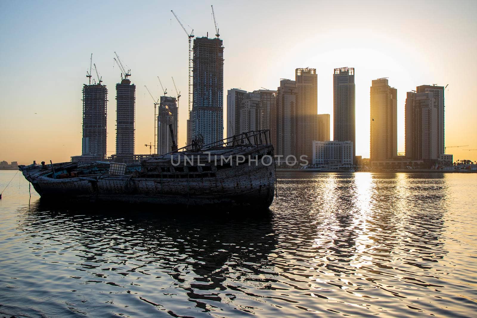 Sunrise in Jadaf area of Dubai, view of Dubai creek Harbor construction of which is partially completed. Old abandoned ships can be seen on the scene. Outdoors