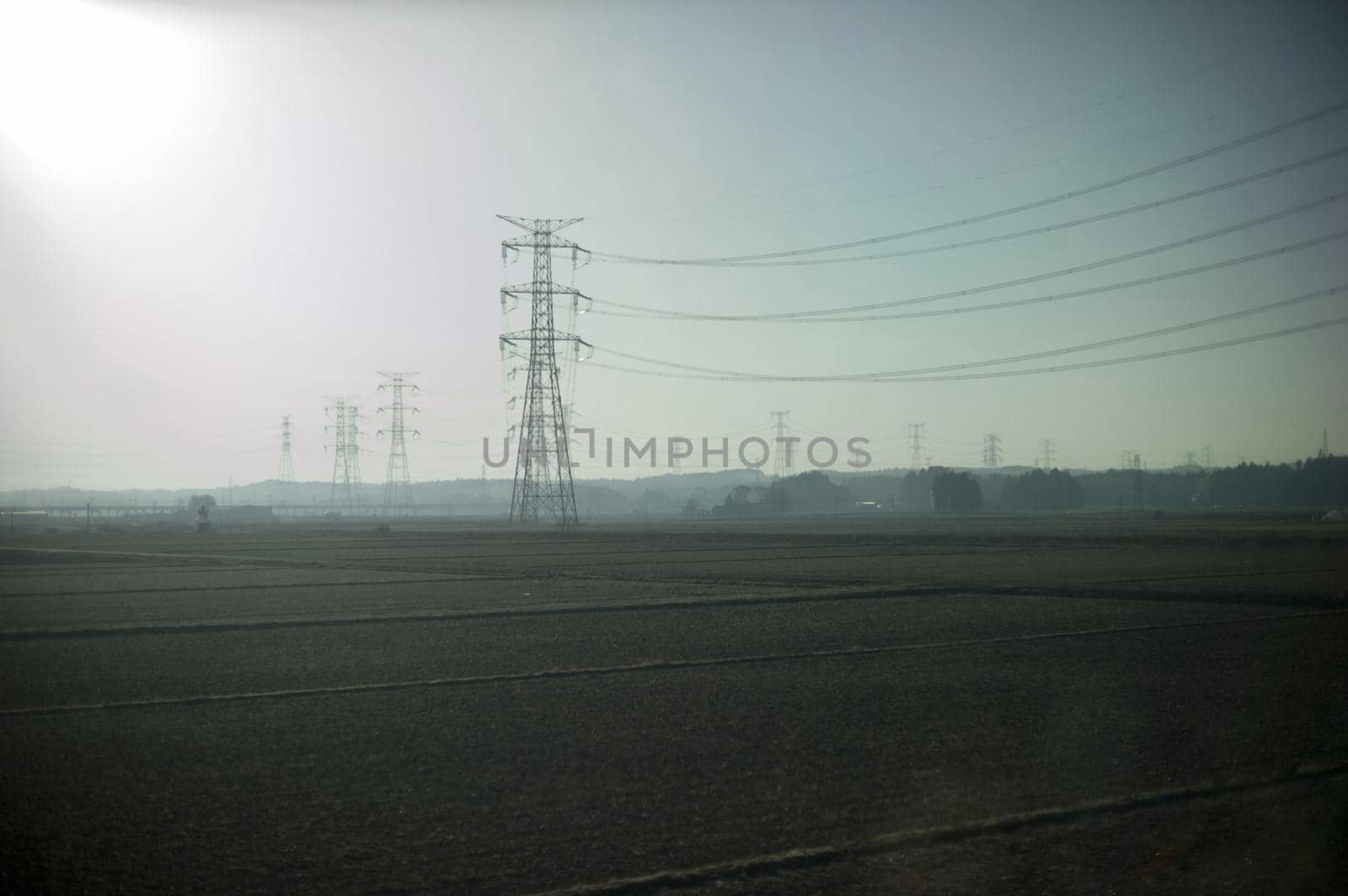 high voltage overhead powerlines with a high key sun flare effect