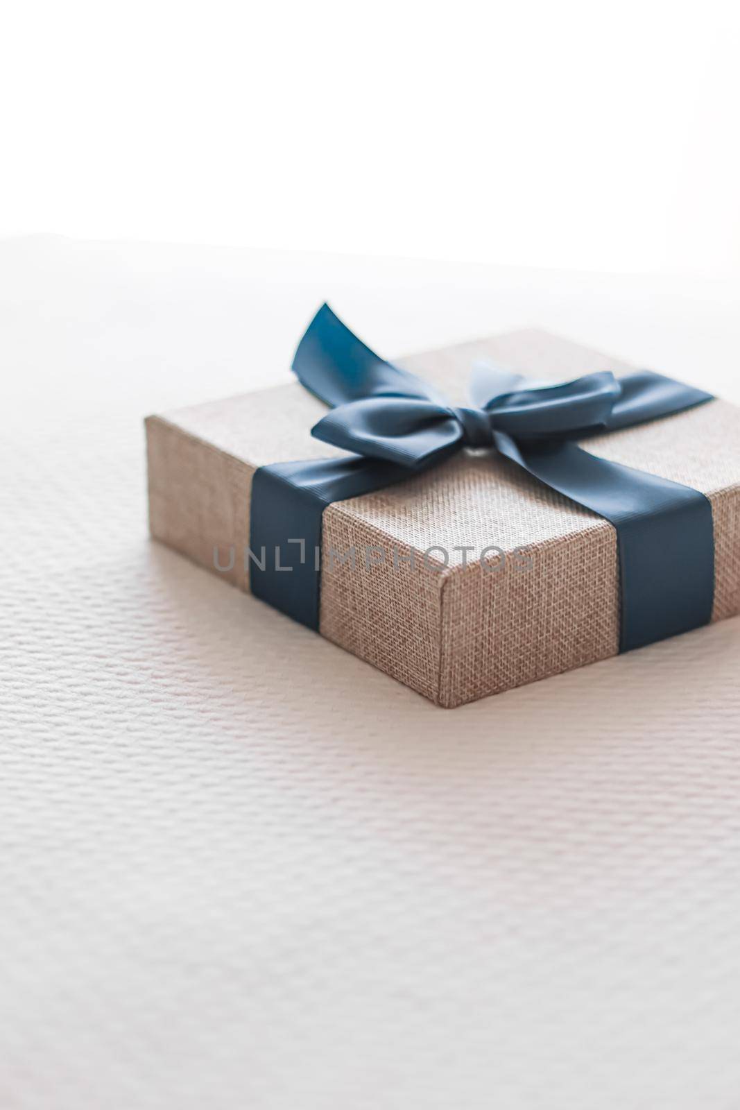 Holiday present and luxury online shopping delivery, wrapped linen gift box with blue ribbon on bed in bedroom, chic countryside style by Anneleven
