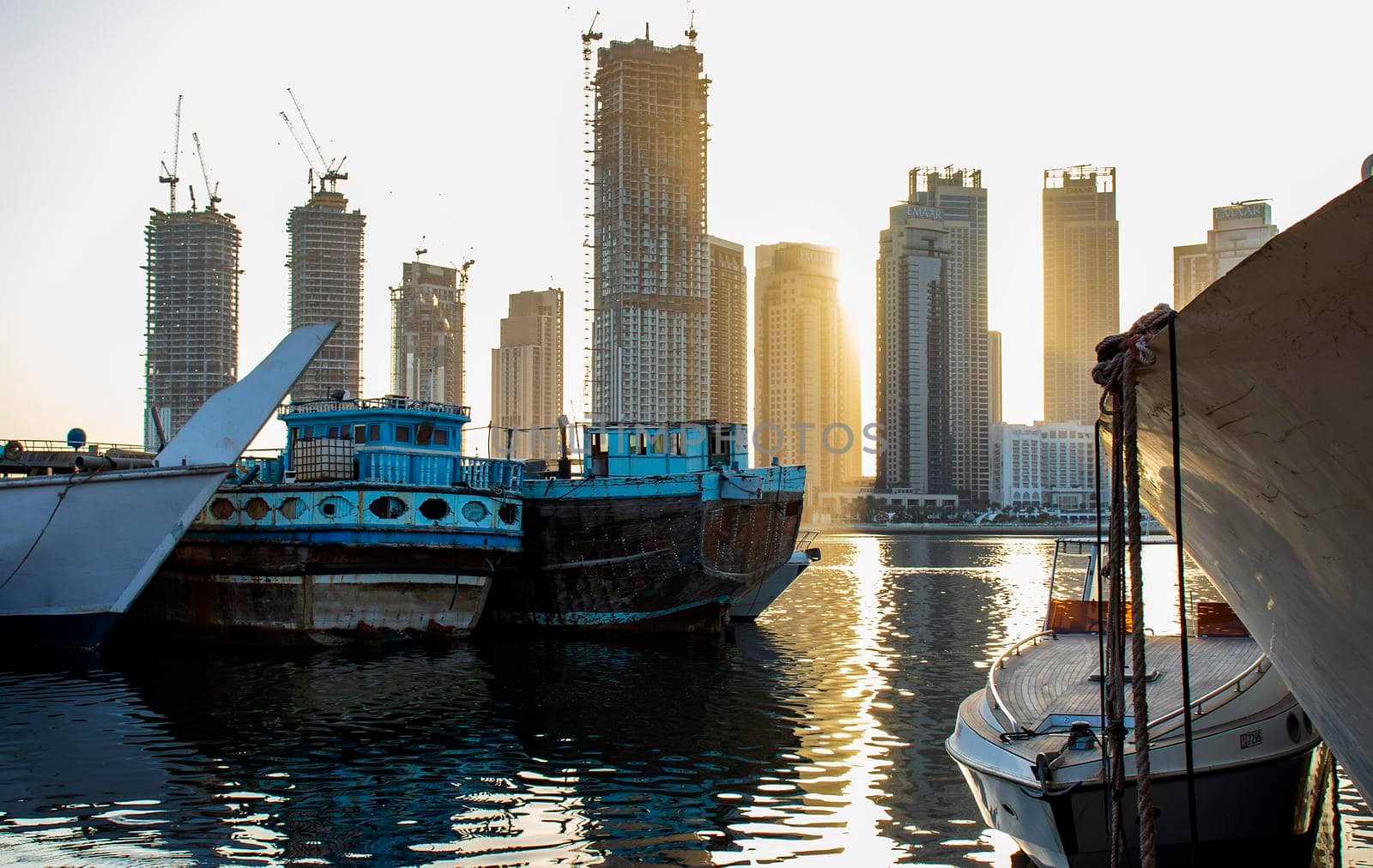 Sunrise in Jadaf area of Dubai, view of Dubai creek Harbor construction of which is partially completed. Old ships and boats can be seen on the scene. Outdoors