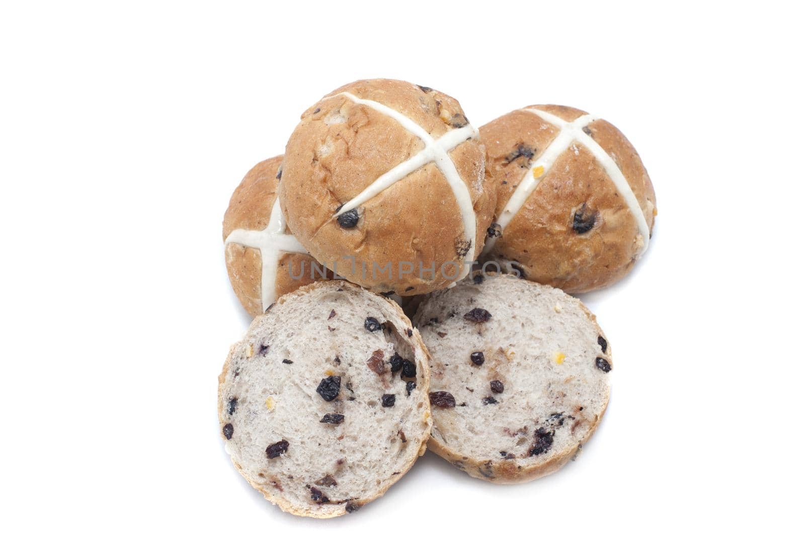 Fresh baked delicious fruity Easter Hot Cross Buns with one slice open to show the raisins and the others arranged to show the cross symbolic of the Crucifixion, on white with copy space