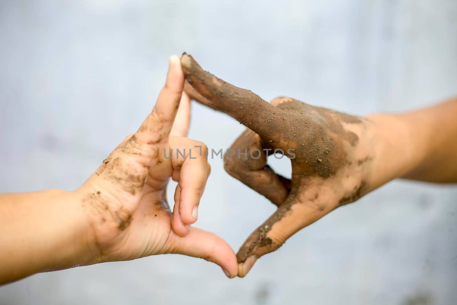 Concept of equality, respect, employment, deal, business with the symbol of handshake b/w a farmer with a hand having mud and a businessman's hand. by mirzamlk