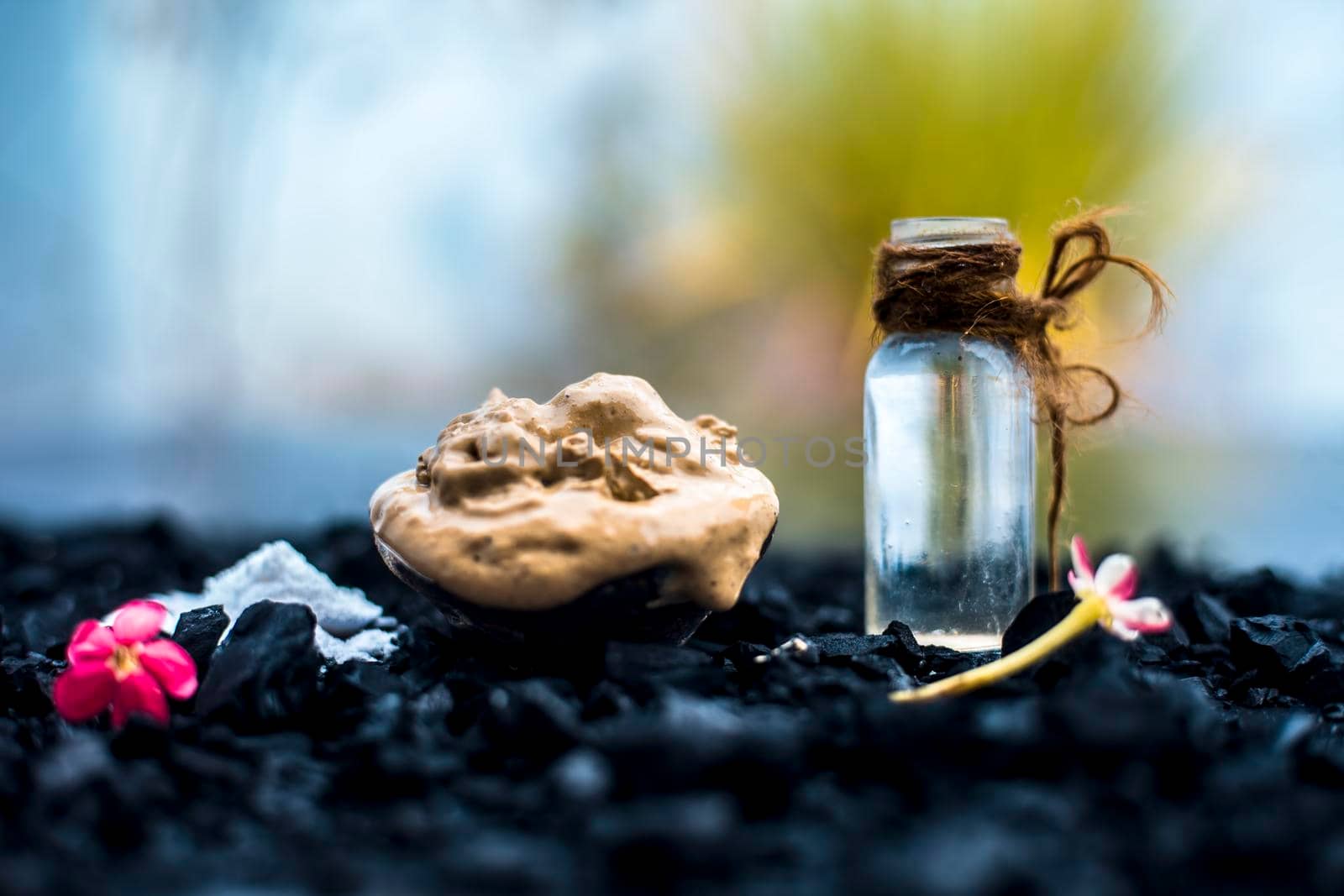 Activated charcoal face mask consisting of bentonite clay or fuller's earth or multani mitti or mulpani mitti well mixed with baking soda and coconut oil. On a wooden surface with entire constituents.