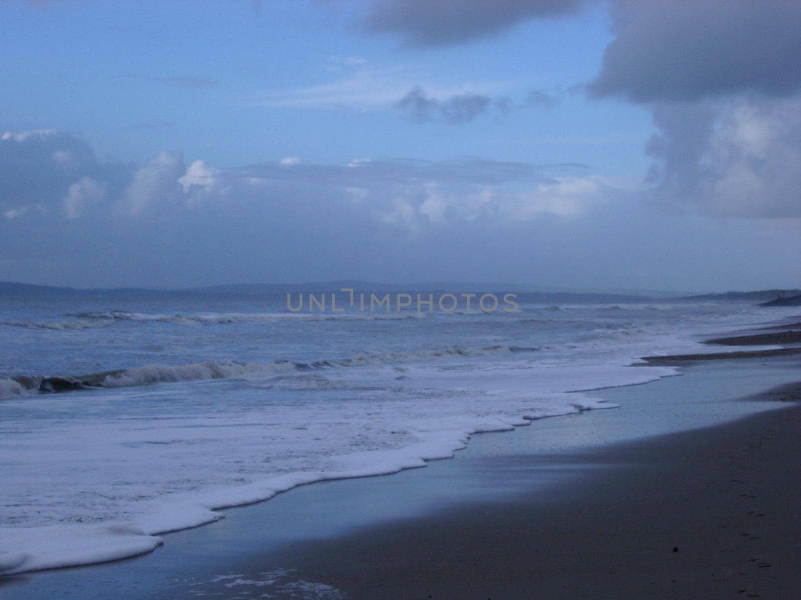 waves breaking under a stormy looking sky