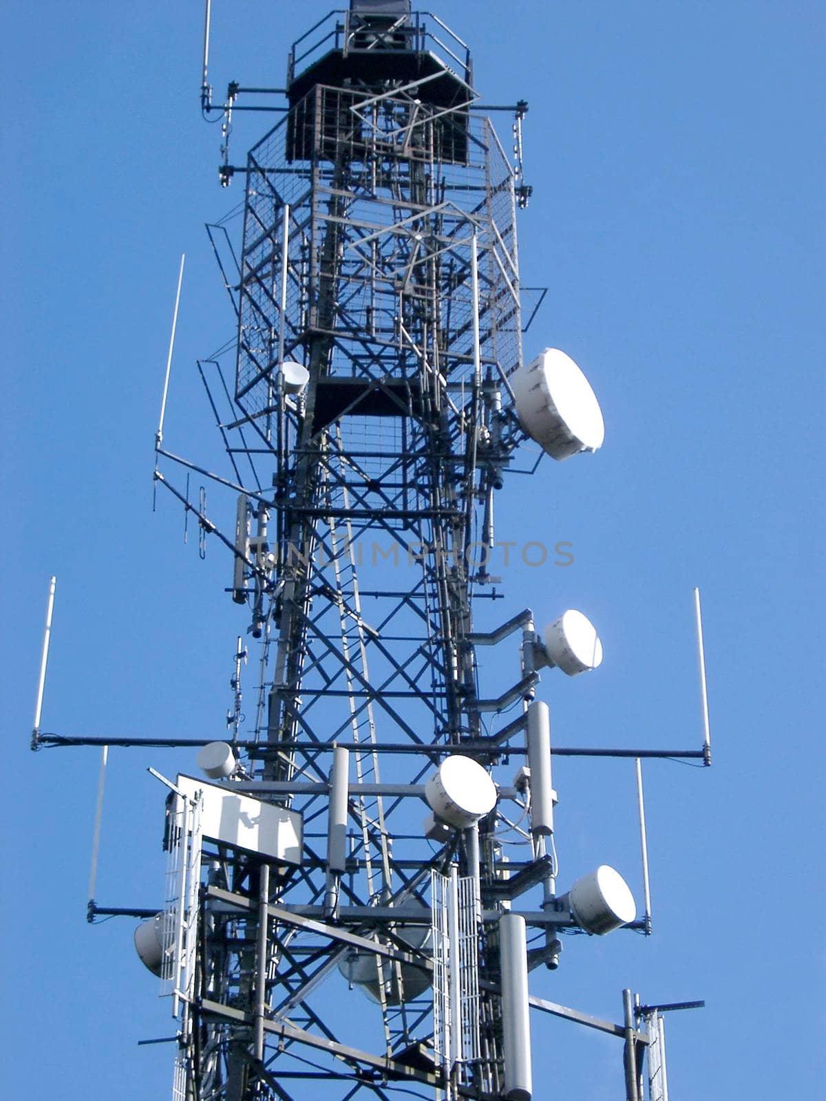 Low angle view of a steel lattice communications tower with an array of dishes for transmission and reception by sanisra