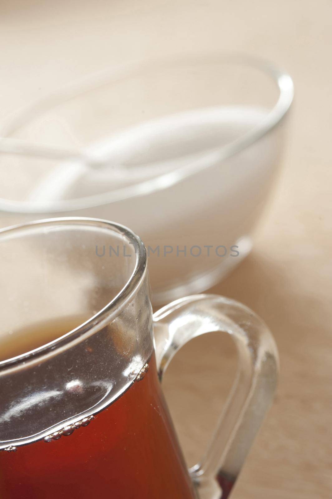 Close-up of glass of black tea and bowl of sugar
