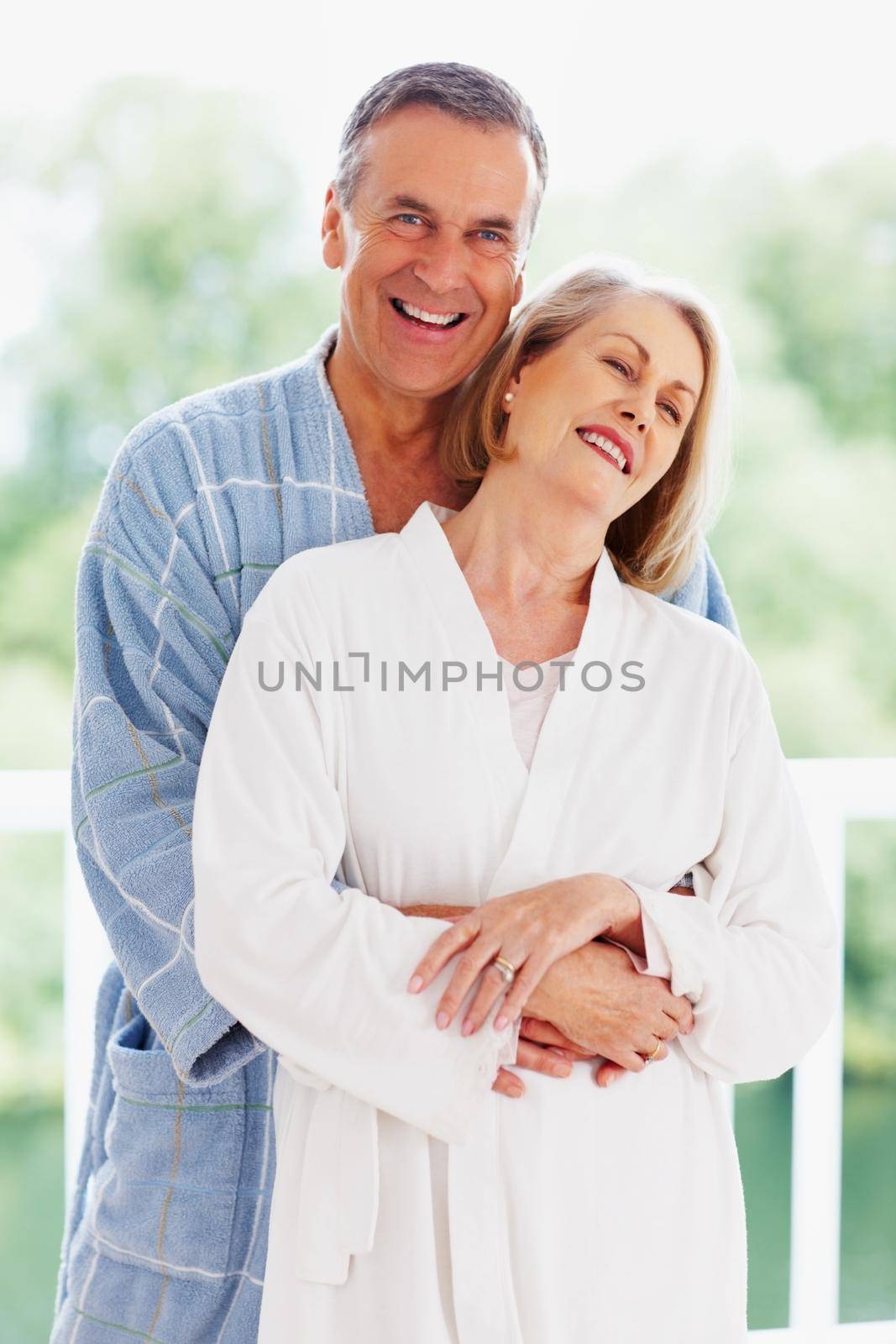 Romantic couple with mature man embracing wife from back. Portrait of a romantic couple with mature man embracing wife from back. by YuriArcurs