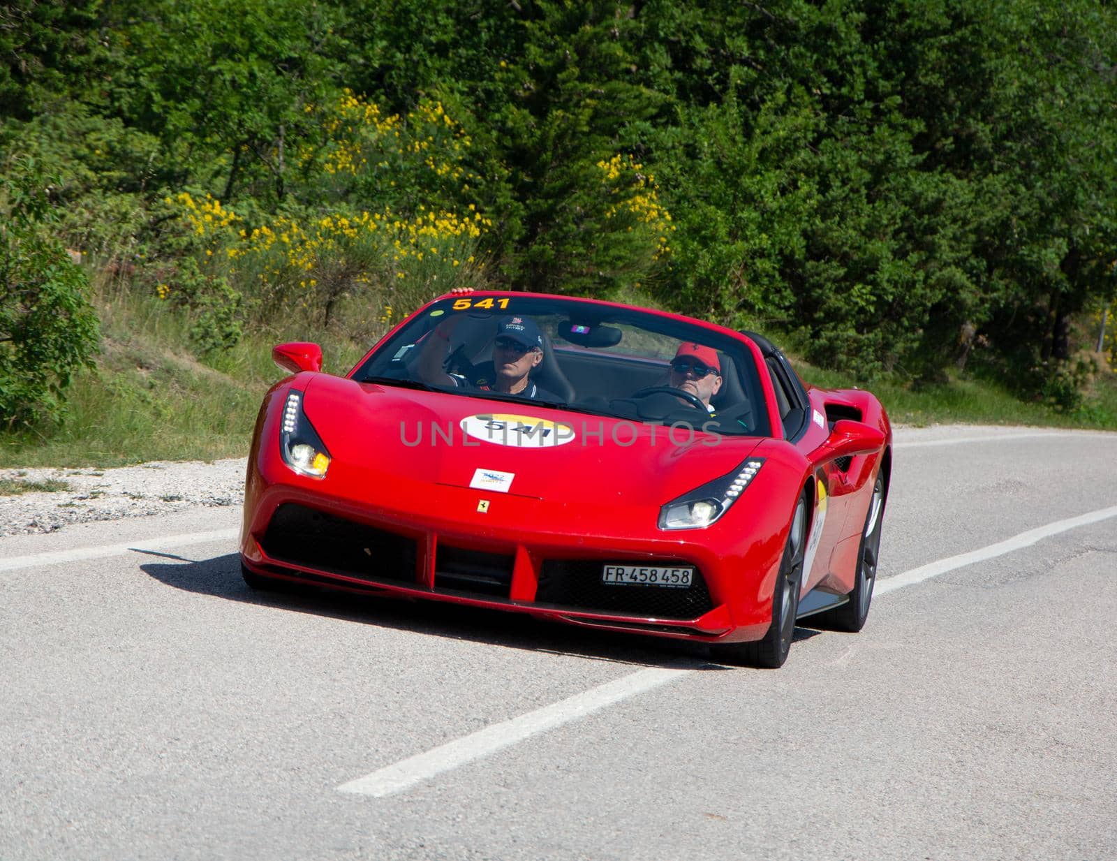 URBINO - ITALY - JUN 16 - 2022 : FERRARI 488 SPIDER 2017 on an old racing car in rally Mille Miglia 2022 the famous italian historical race (1927-1957