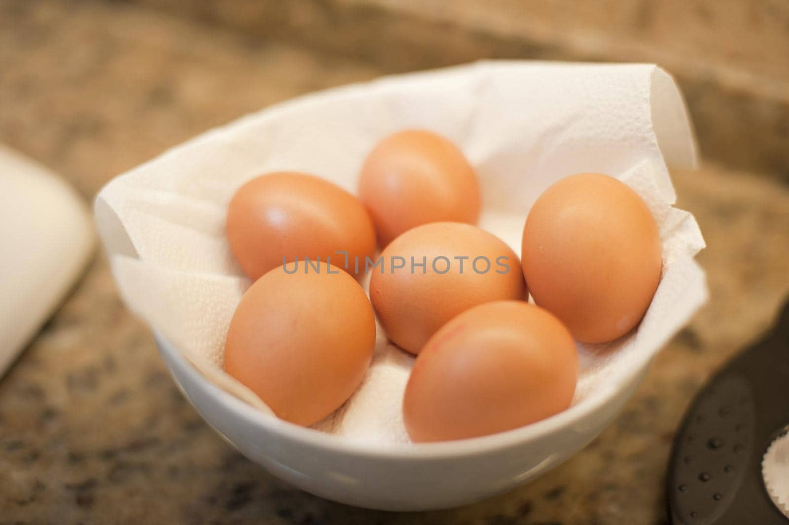 Delicious brown fresh free range farm eggs nestling in paper in a bowl waiting to be used as a cooking ingredient or for a tasty breakfast