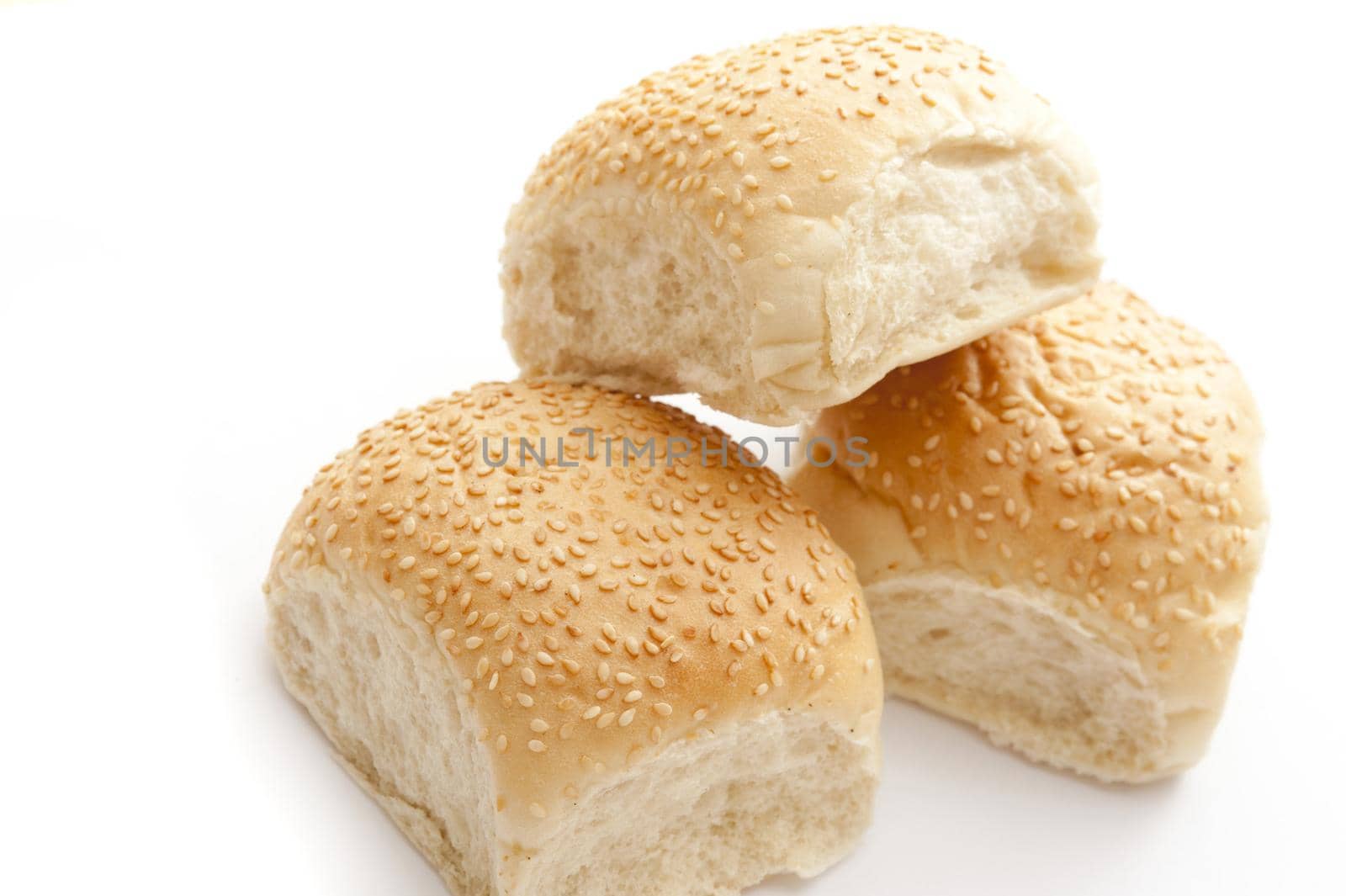 Close Up Still Life of Three White Sesame Bun Bread Rolls Stacked on White Studio Background with Copy Space