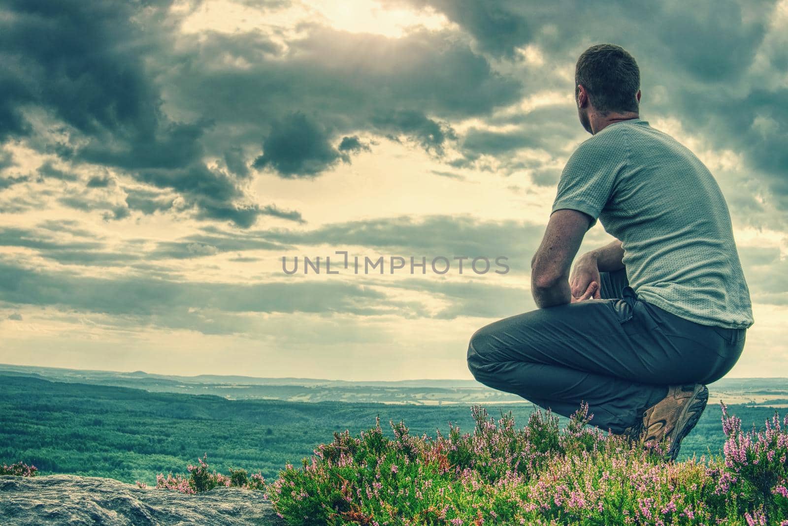Tall man sits on a hillside in heather bush by rdonar2