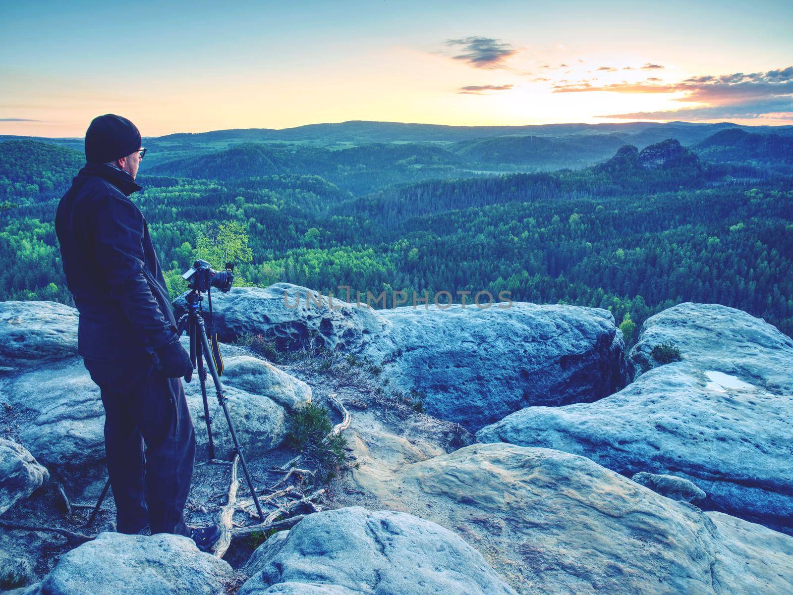 Photographer on mountain cliff take picture of landscape awaking. by rdonar2