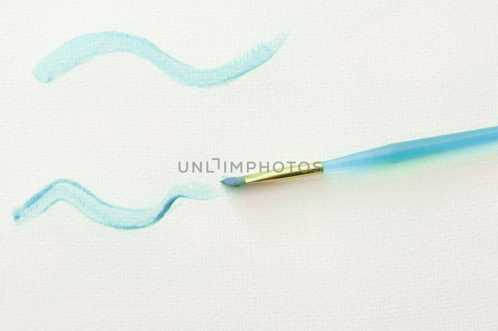 High Angle Still Life of Plastic Child Paintbrush Painting Squiggly Lines in Blue Paint on White Paper Background with Copy Space