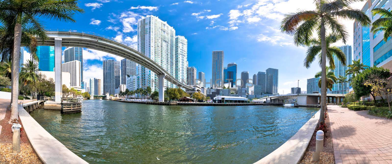 Miami downtown skyline and futuristic mover train above Miami river panoramic view by xbrchx