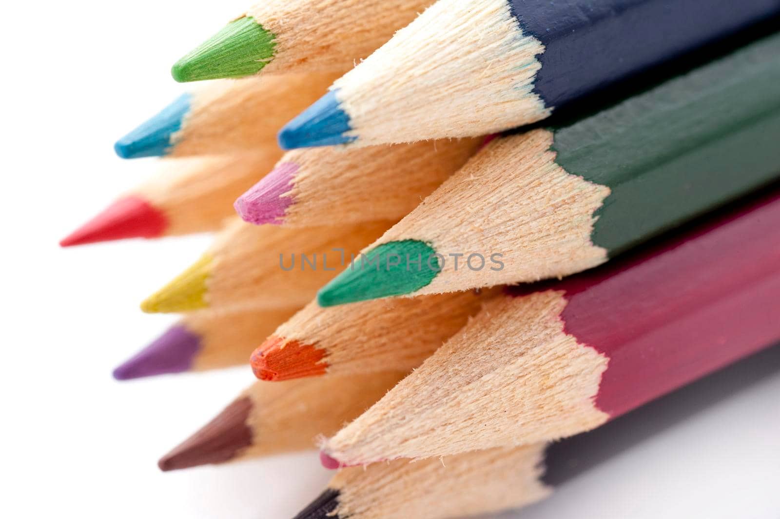 Closeup of the tips of a selection of colouring pencils over white background