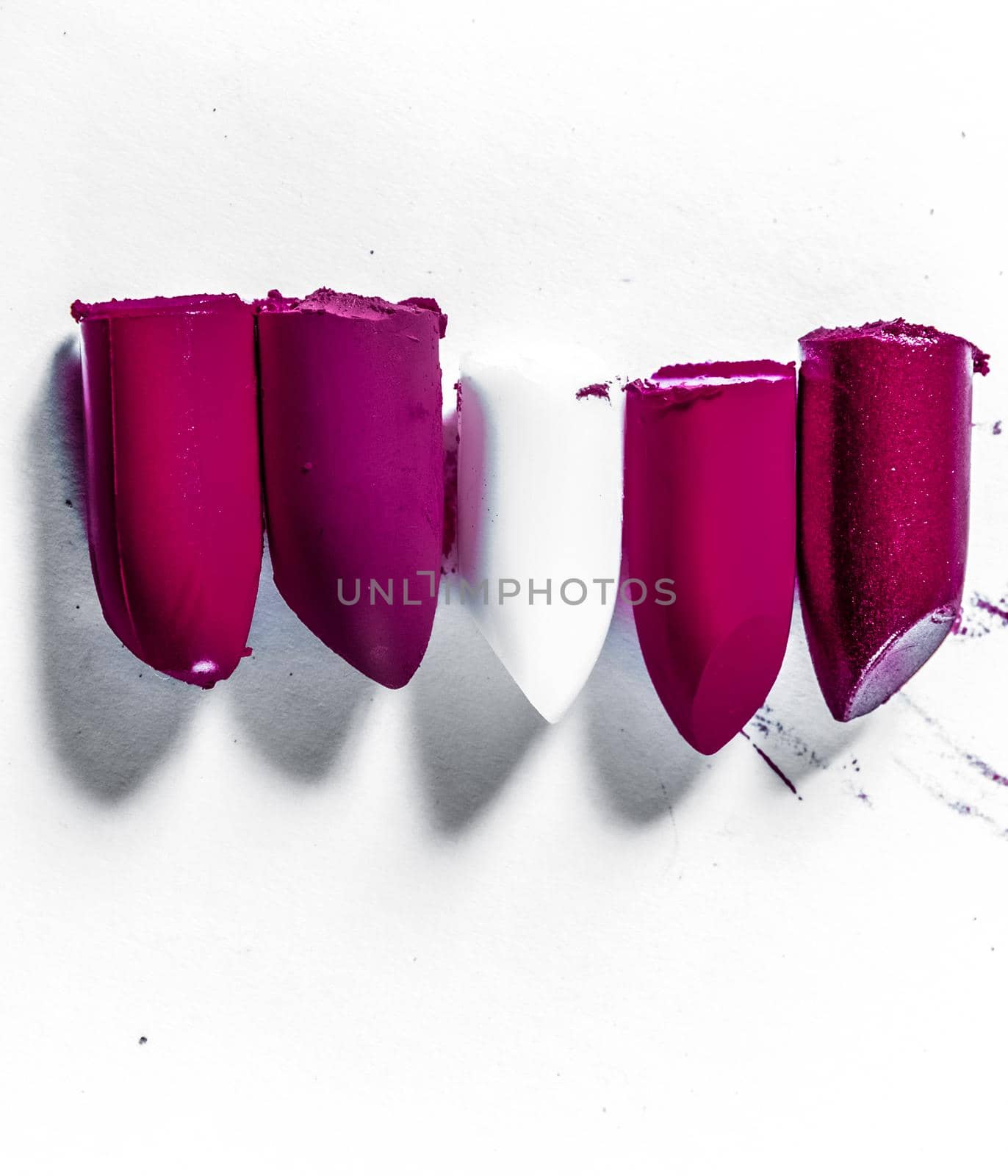 Beauty texture, cosmetic product and art of make-up concept - Cutted lipstick close-up isolated on white background