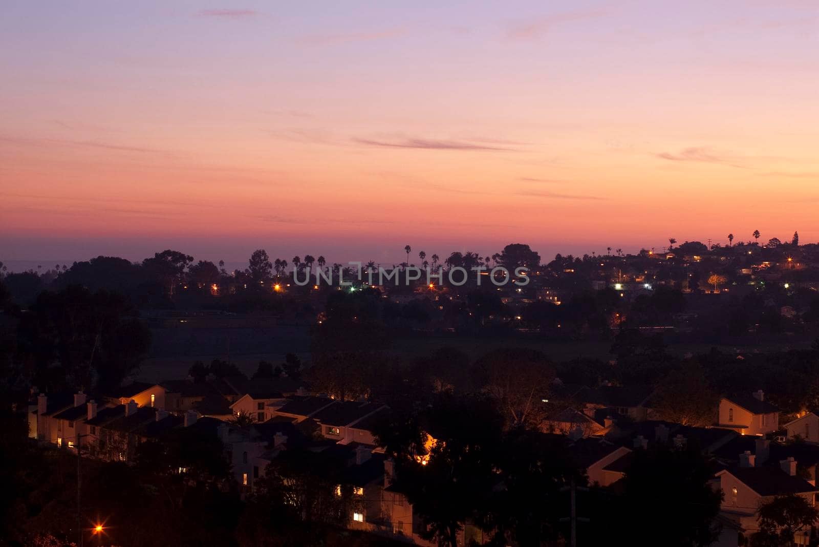 golden orange light of sunset illiminates beach side suburbs