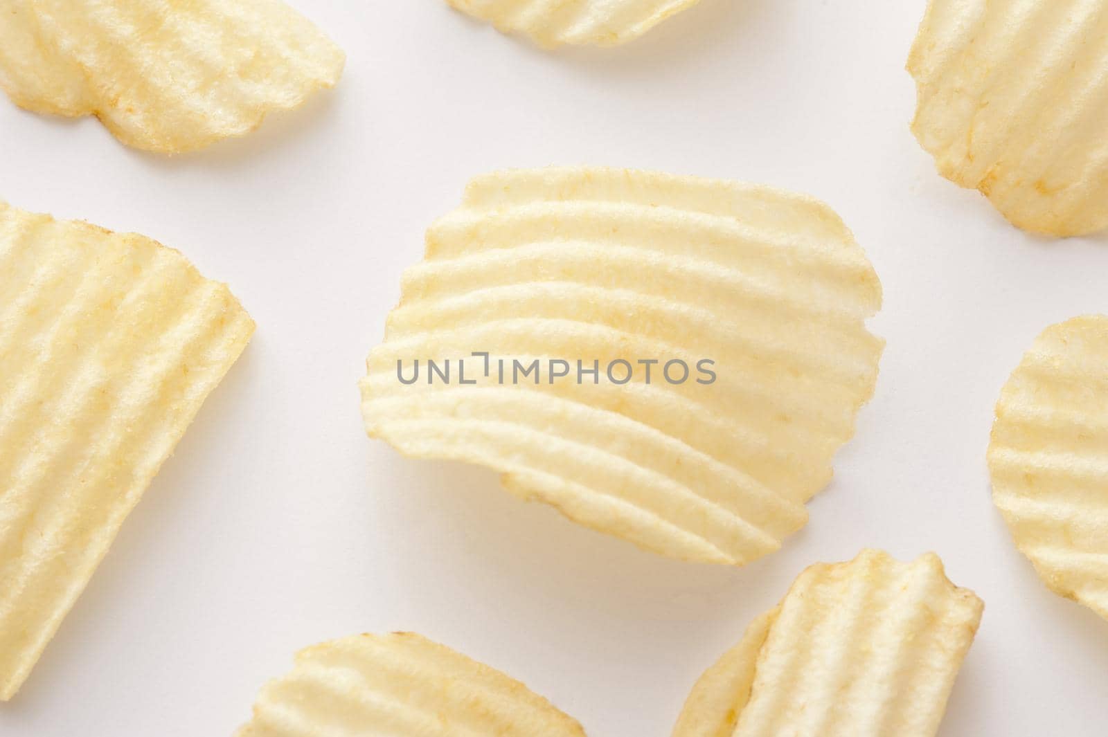 Close up on centered curved ridged potato chip for background about snack or junk food