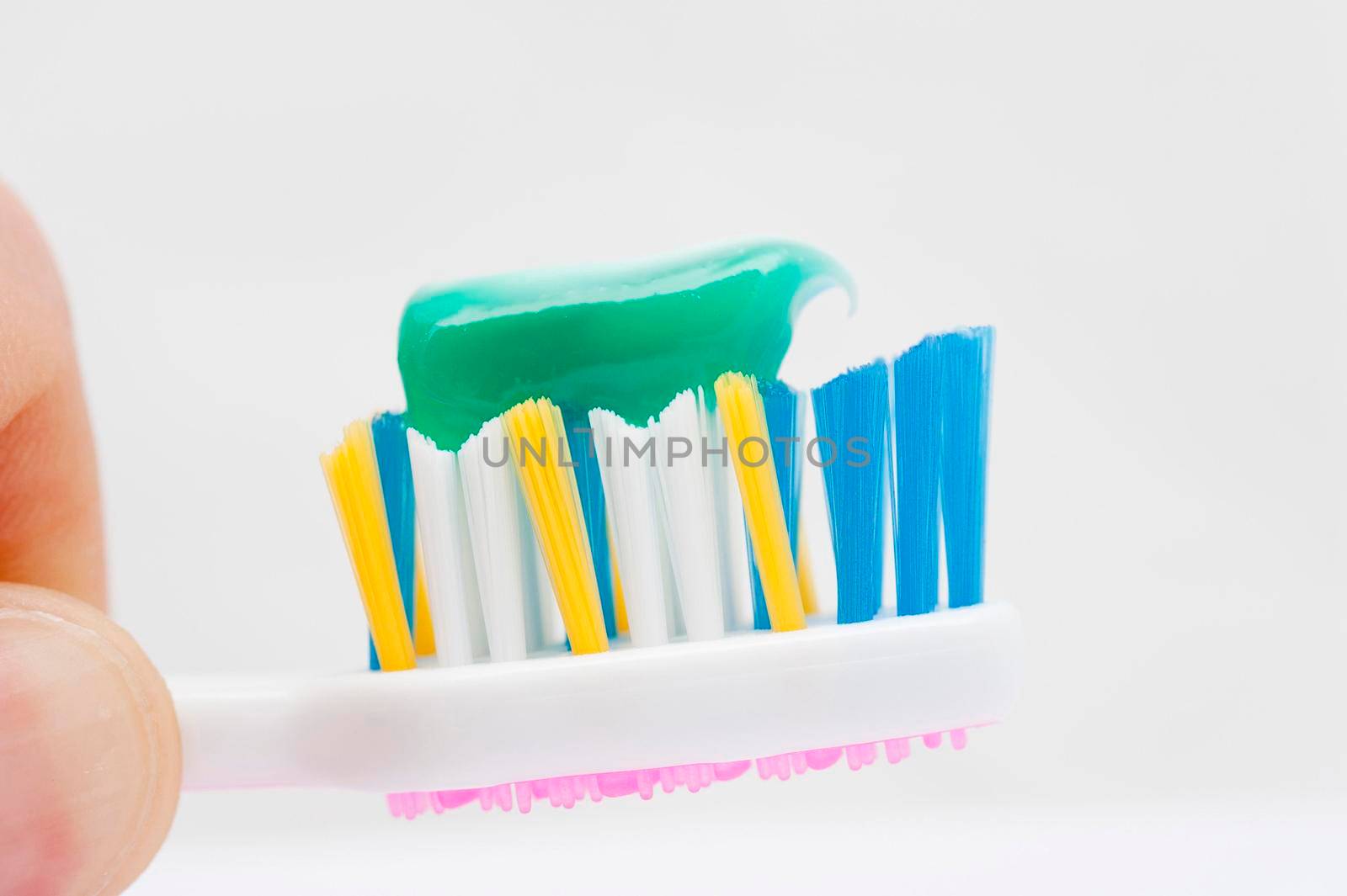 close up on a toothbrush with green toothpaste on it