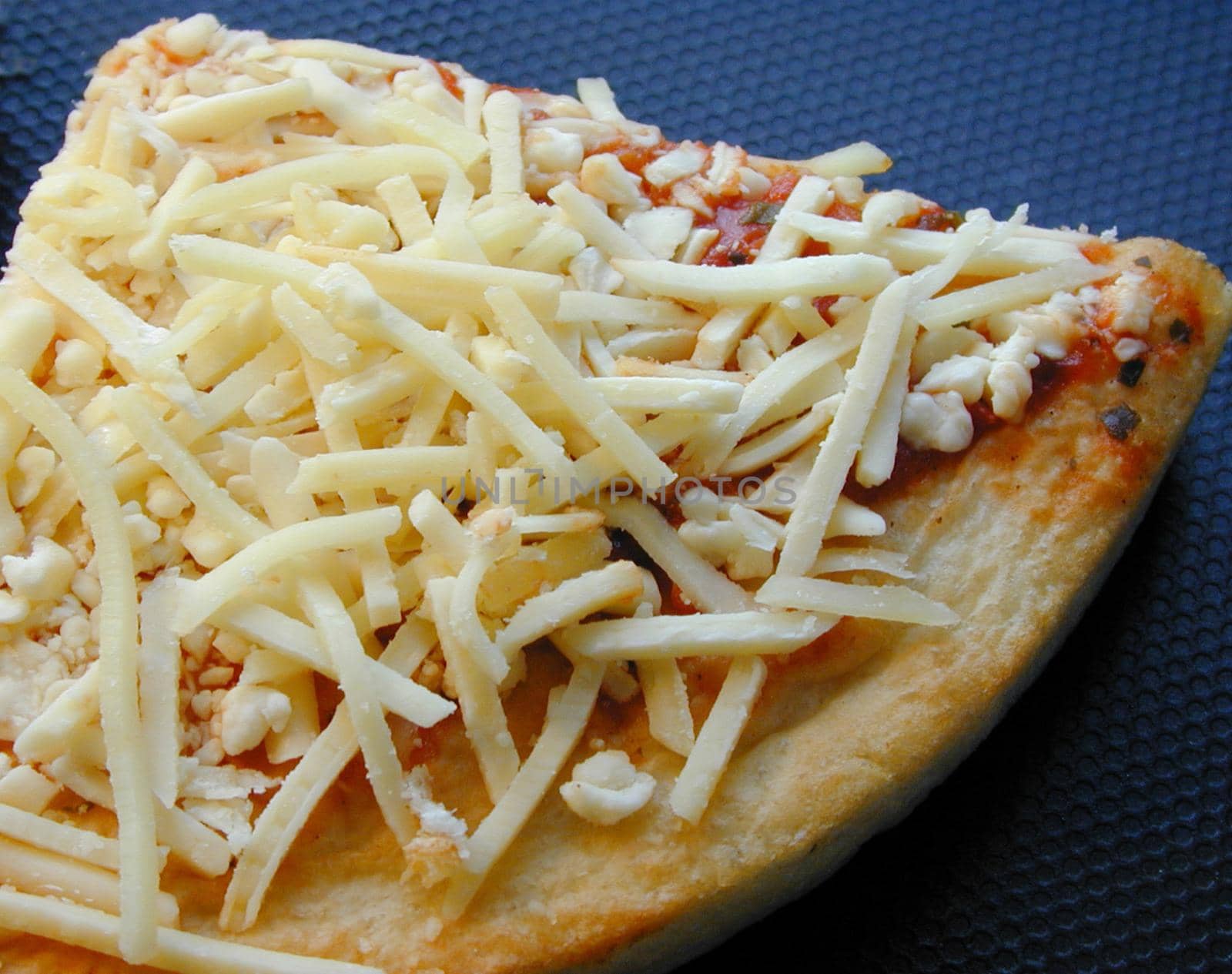 Slice of uncooked Italian pizza with a pastry base topped with tomato paste and grated cheese