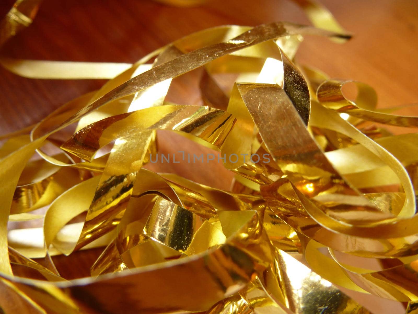 Close up Tangled Gold Foil Cuttings on Top of Wooden Table