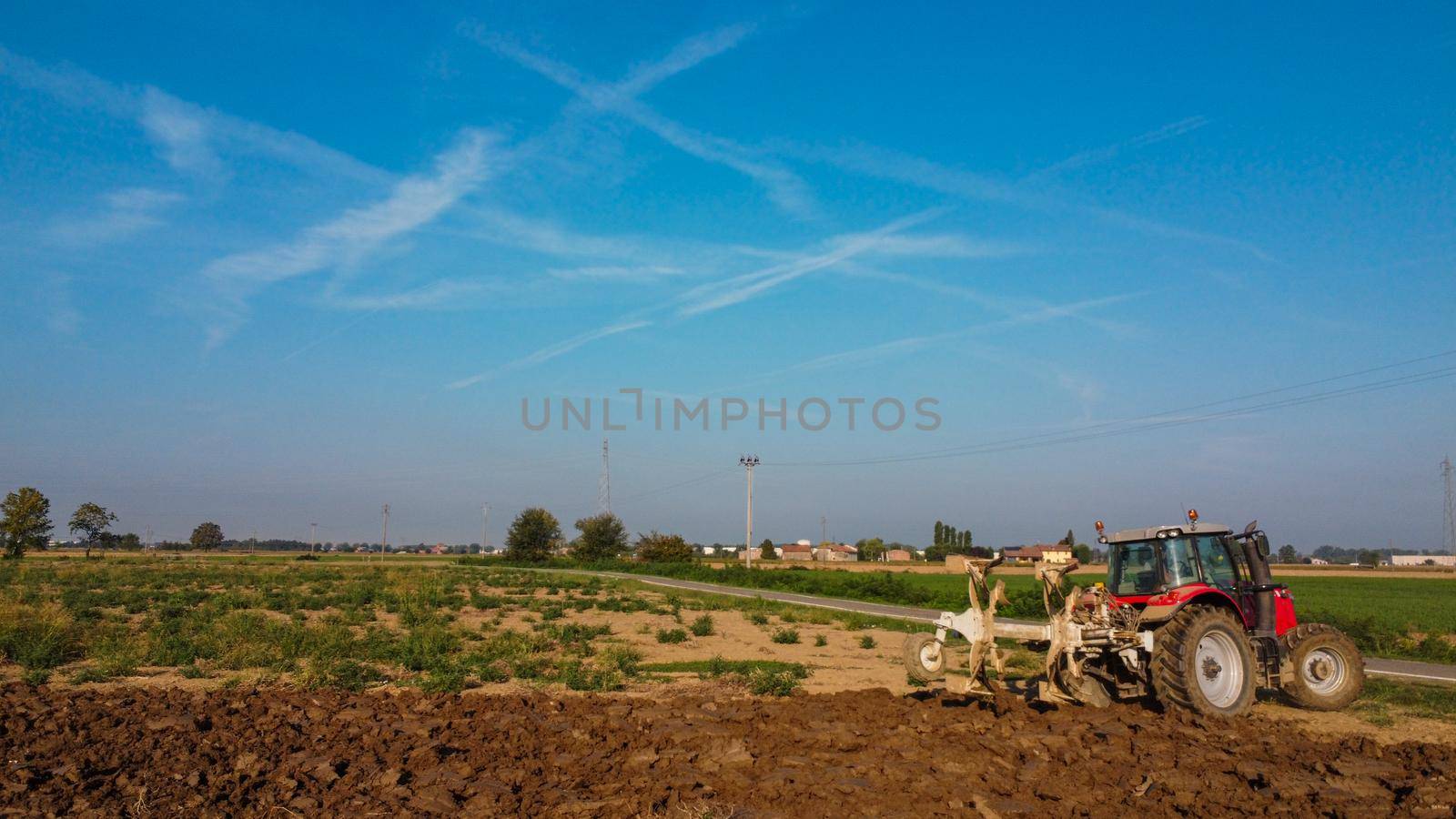 Aerial view with drone of tractor plowing the land in the countryside.