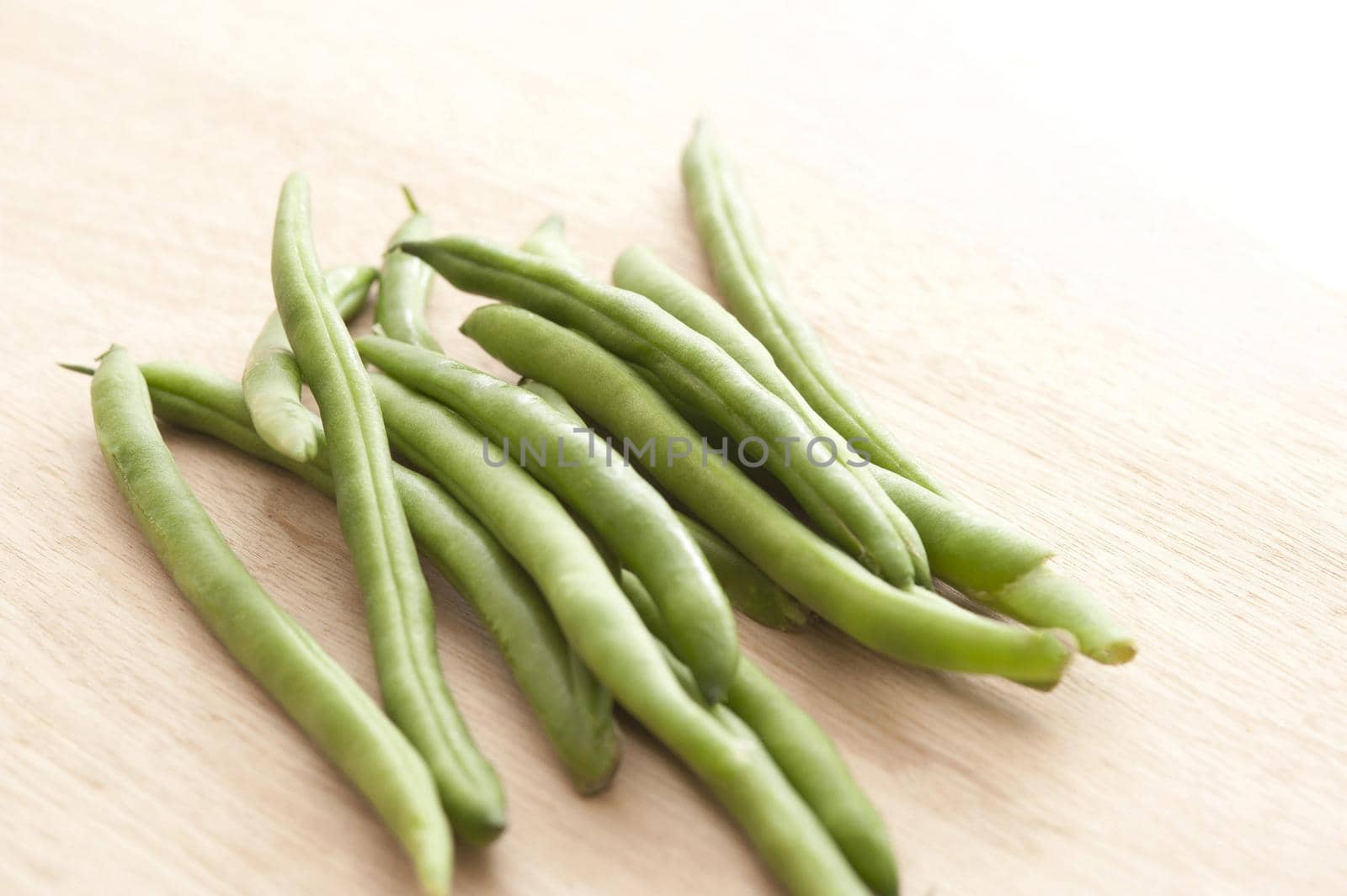 Pile of green runner beans on wooden table