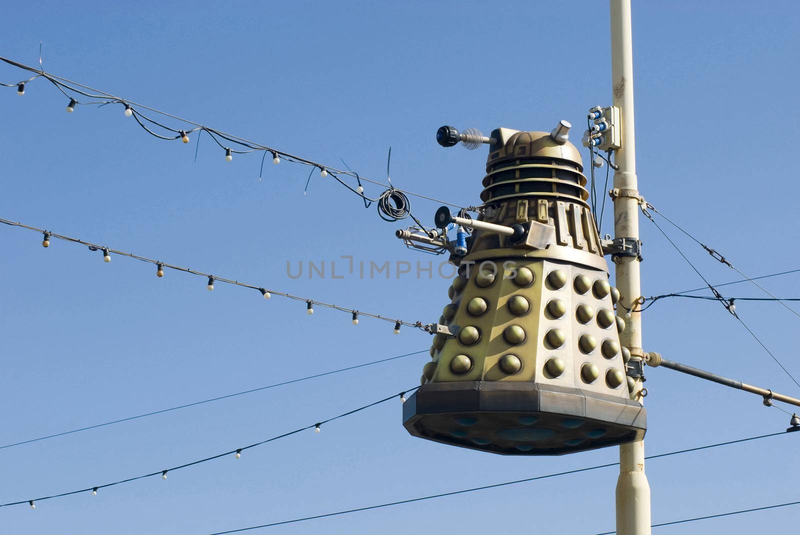 Hiding behind the sofa when Blackpool illuminations comes on the tv? Homage to the doctor who character attached to street a pole against a blue sky