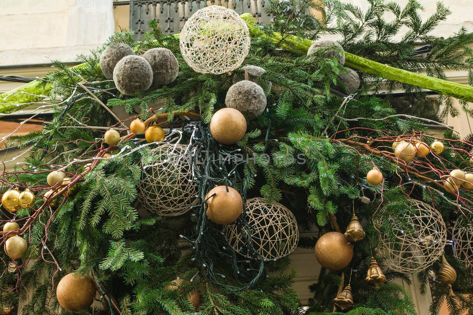 Decoration made from fir branches and golden balls on the wall of a shop