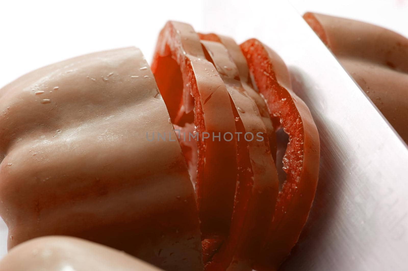 Sliced fresh red bell pepper, sweet pepper or capsicum rich in antioxidants and vitamins in a close up view over a white background
