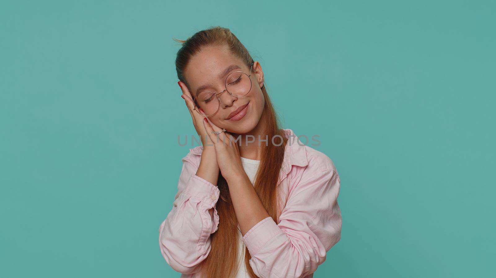 Tired overworked teenager young girl yawning, sleepy inattentive feeling somnolent lazy bored gaping suffering from lack of sleep. Bored student child kid isolated on blue studio background indoors