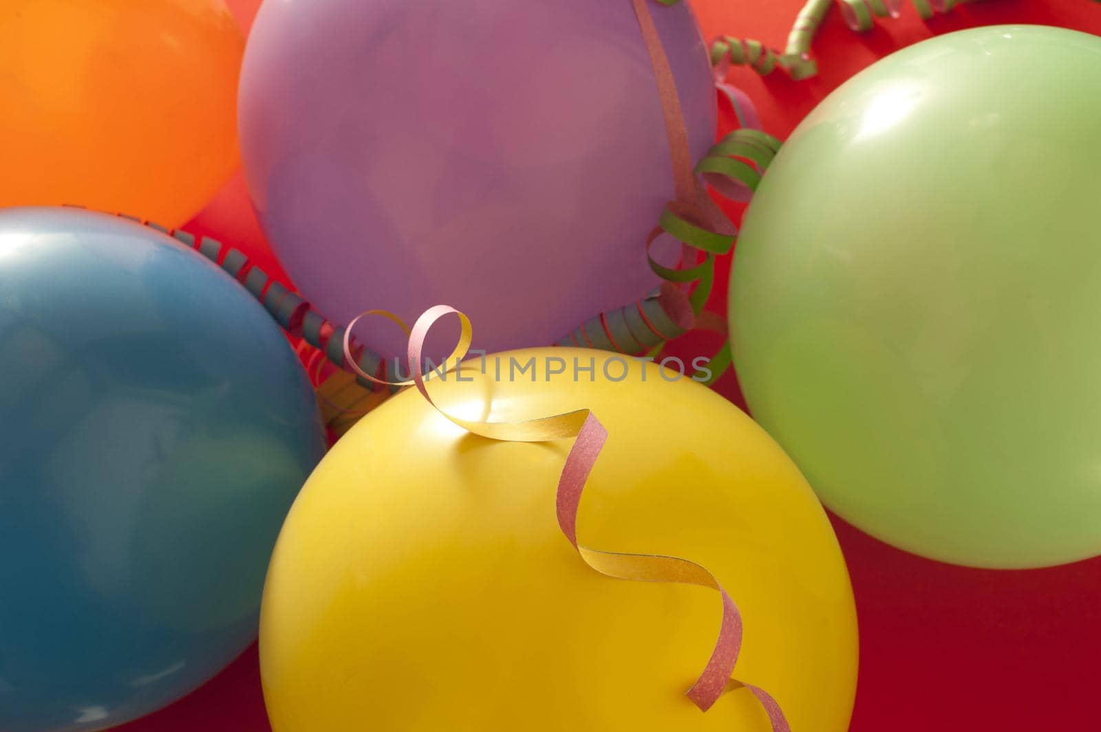 Party or celebration background of colorful balloons and spiral streamers in a close up full frame view from above
